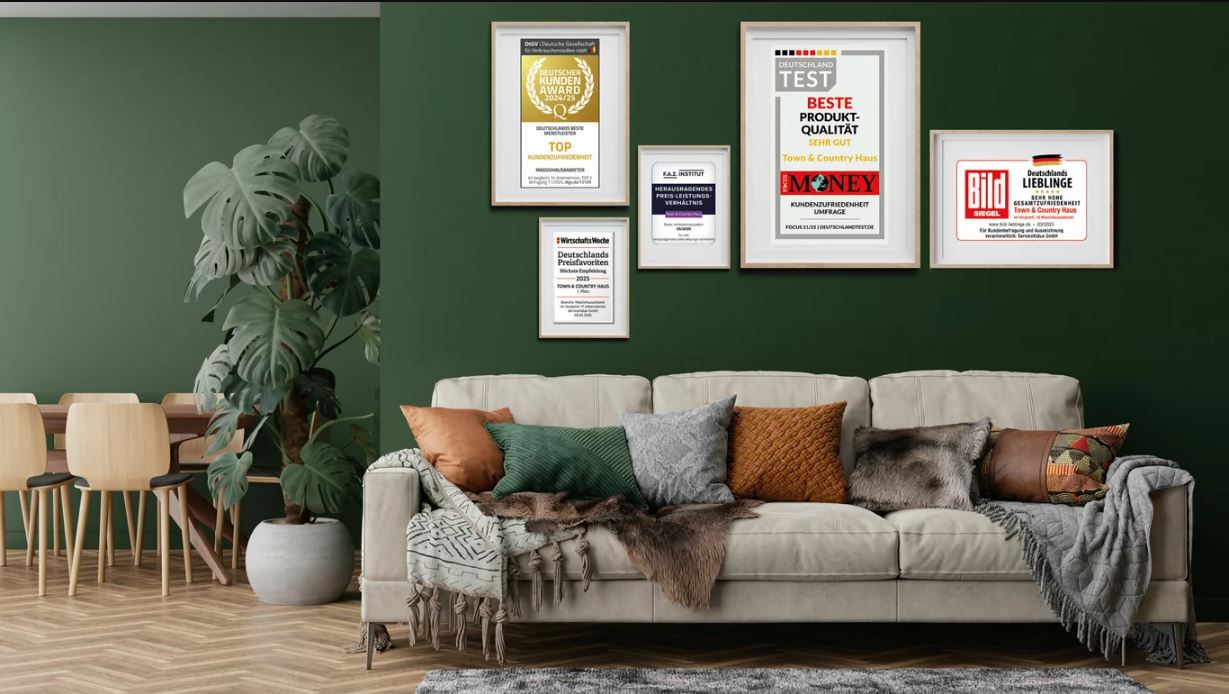 Wohnzimmer mit Sofa und Hausbauauszeichnungen an der Wand